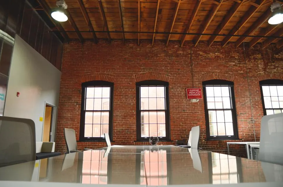 Salle de bureau aux murs de briques après un entretien ménager commercial à Laval