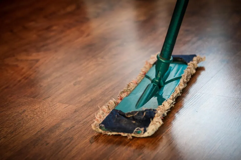 Lavage d'un plancher de bois avec une vadrouille